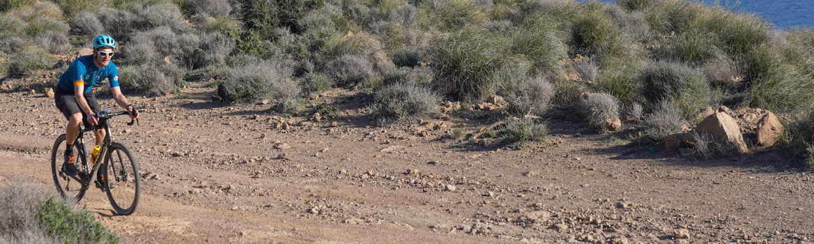 Cycliste gravel sur une piste en bord de mer en Andalousie