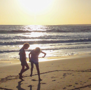 Enfants qui jouent sur la plage au soleil couchant